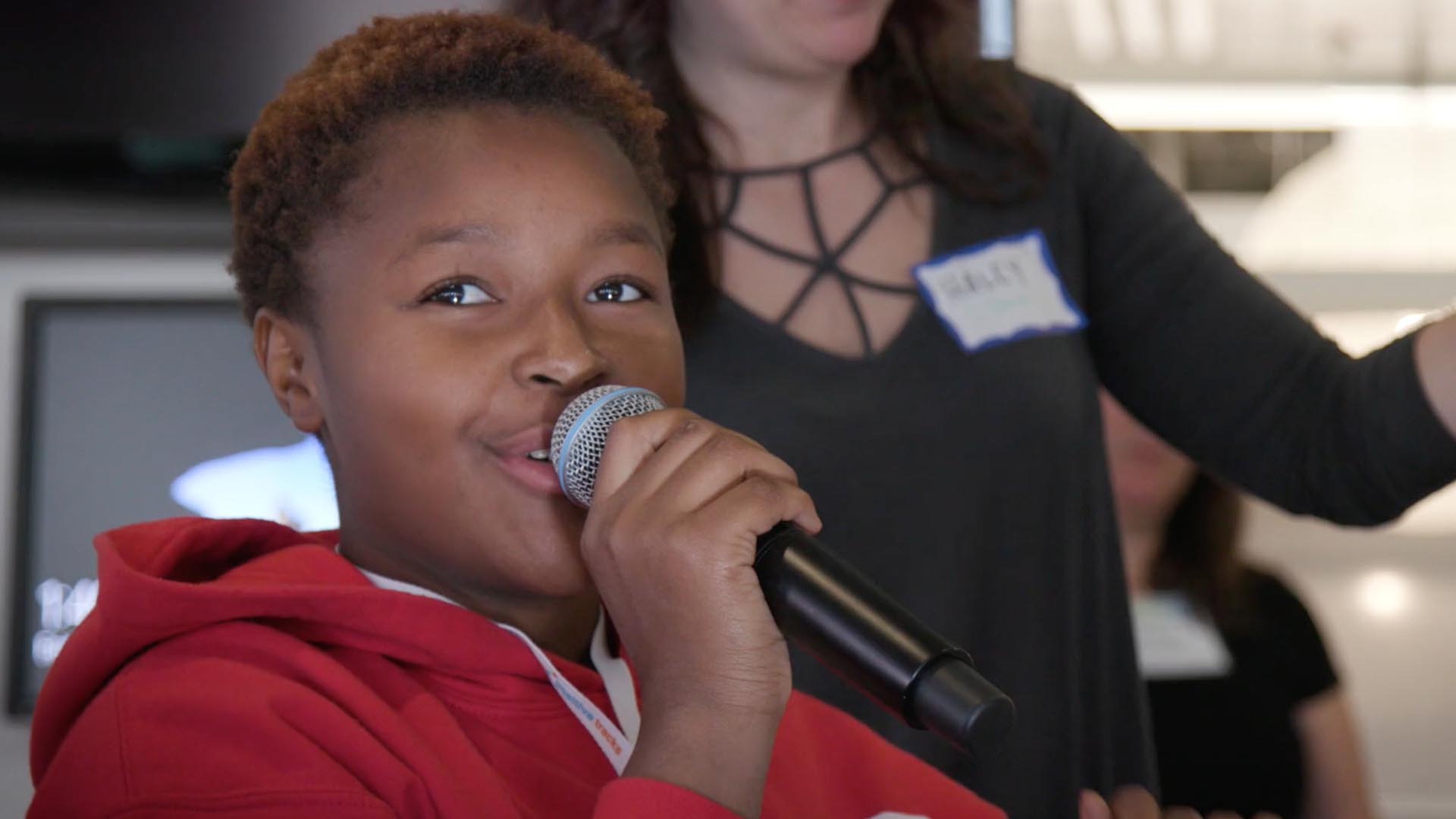 young person speaking into a microphone